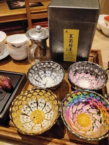 Reviewer's four Vivid Gold peacock cups in gold, silver, pink, and iridescent colors on a wooden tray.