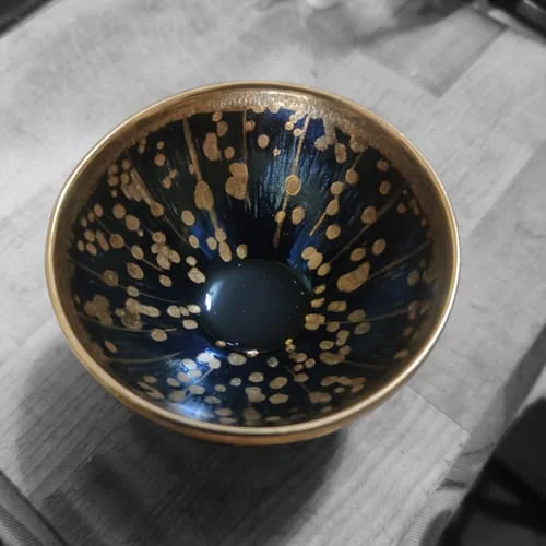 Customer's Golden Drops cup viewed from above, showing the blue and gold speckled interior.