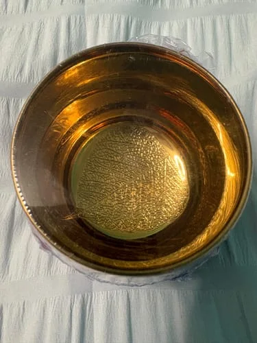 Close-up of the customer's Crane tea cup, showing the shimmering, gold interior through its plastic wrap.